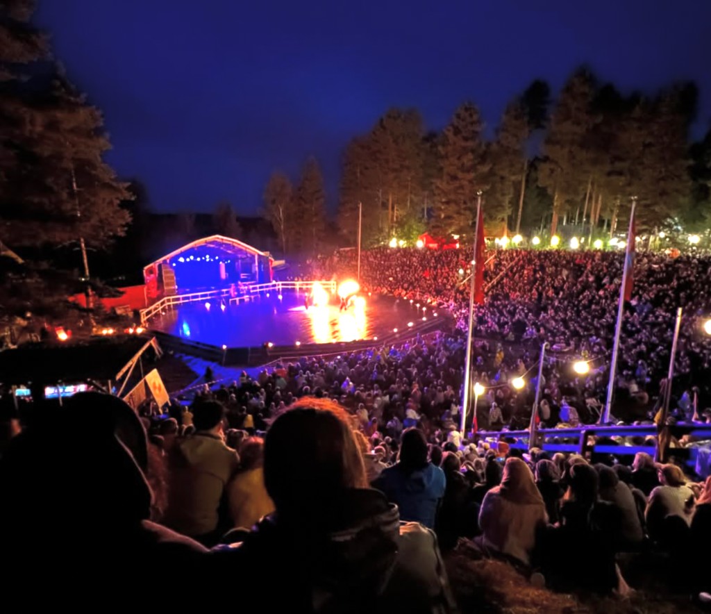 Publik på Urkult-festivalen i Näsåker med eldshow och scen i blått ljus